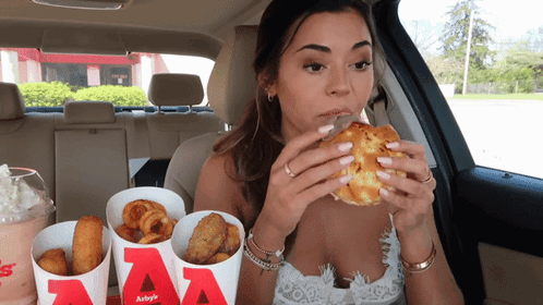 Woman Sitting in Car Eating Hamburger From Bucket Saying AA