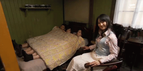 Woman Sitting in Chair in Front of Bed