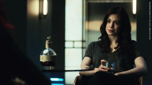 Woman Sitting In Chair Next To Whiskey GIF