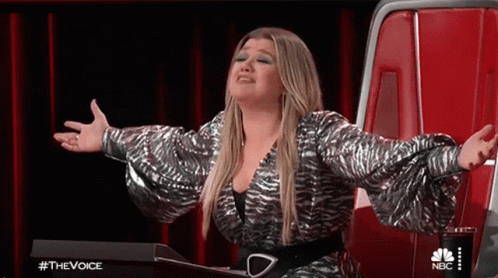 Woman Sitting in Chair With Arms Outstretched on Stage
