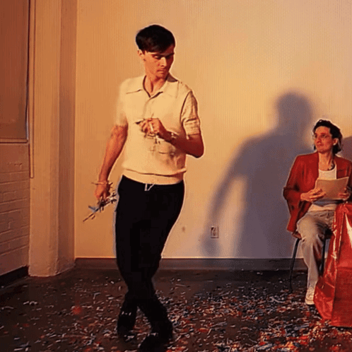 Woman Sitting In Chair With Man Standing GIF