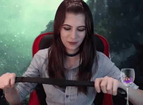 Woman Sitting In Chair With Wine And Belt GIF