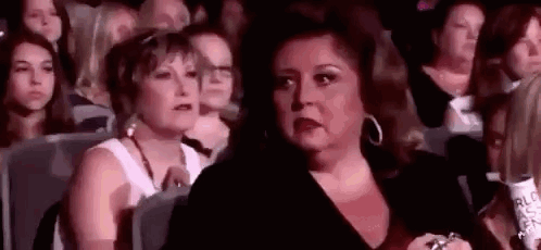 Woman Sitting in Crowd Watching Performance
