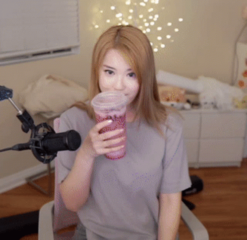 Woman Sitting in Front of a Microphone Holding a Cup