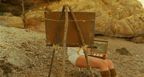 Woman Sitting in Front of Easel With Painting