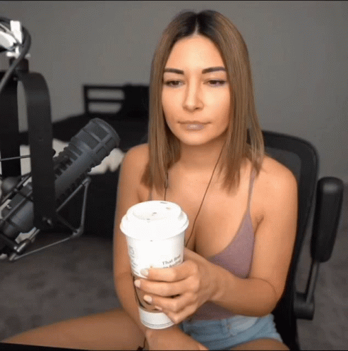 Woman Sitting In Front Of Microphone Holding Coffee