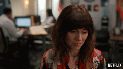 Woman Sitting In Front Of Netflix Sign GIF