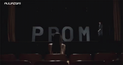 Woman Sitting in Front of Prom Sign