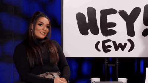 Woman Sitting in Front of Sign Saying Hey