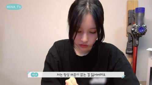 Woman Sitting in Front of Vacuum Cleaner With Mina TV