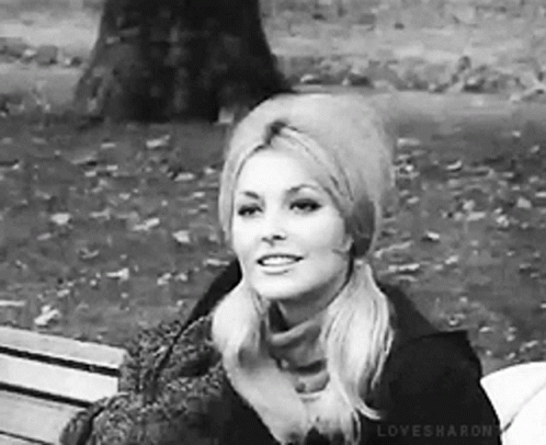 Woman Sitting in Park with Hat and Scarf