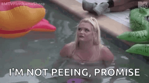 Woman Sitting in Pool with Inflatable Crocodile and Pink Duck