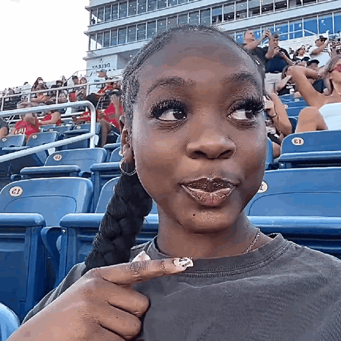 Woman Sitting In Stadium Pointing At Shirt GIF