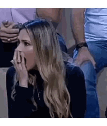 Woman Sitting in Stadium with Hand on Face
