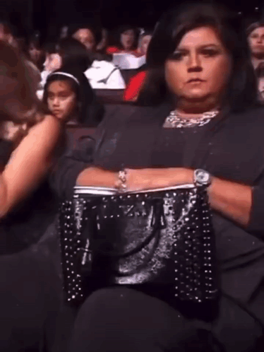 Woman Sitting in Theater With Black Purse