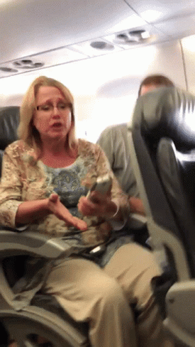 Woman Sitting On Airplane Looking At Cell Phone GIF