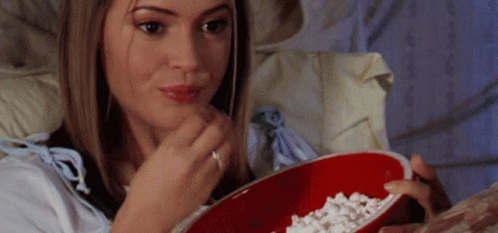 Woman Sitting on Bed Eating Popcorn