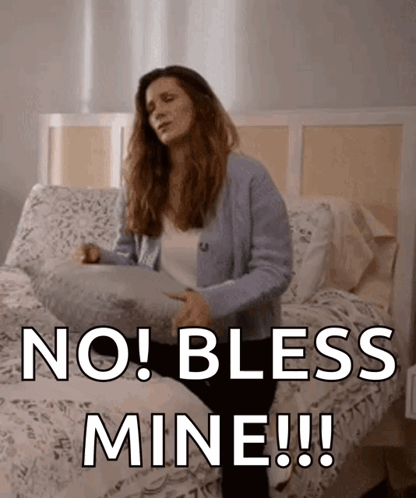 Woman Sitting on Bed Holding Pillow No Bless Mine