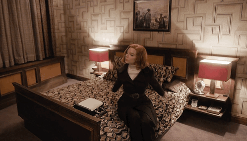 Woman Sitting on Bed With Picture Above
