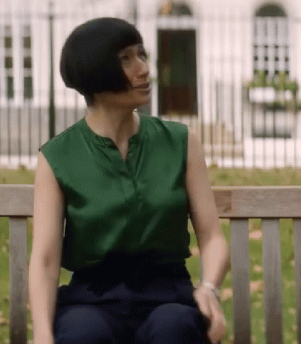 Woman Sitting on Bench Green Top Blue Pants