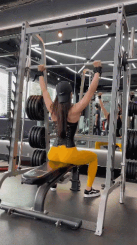 Woman Sitting On Bench In Gym Holding Barbell Overhead GIF