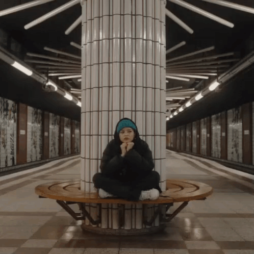 Woman Sitting On Bench In Subway Station GIF