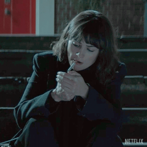 Woman Sitting On Bench Lighting Cigarette GIF