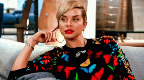 Woman Sitting On Couch In Butterfly Sweater GIF