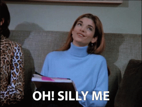 Woman Sitting on Couch Saying Oh Silly Me