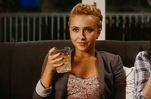 Woman Sitting On Couch Smiling Holding Glass Of Water GIF