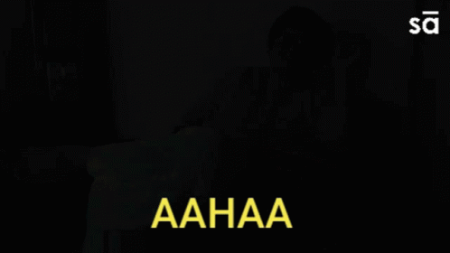 Woman Sitting on Couch With Aahaa in Yellow Letters