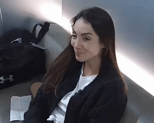 Woman Sitting On Couch With Black Under Armour Bag GIF