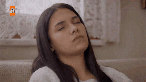 Woman Sitting on Couch with Eyes Closed