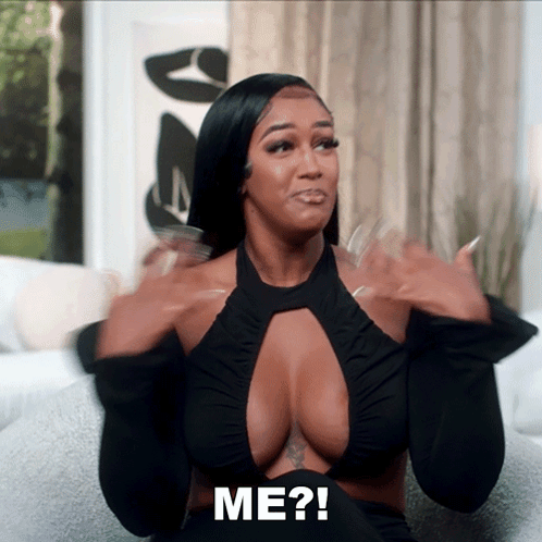 Woman Sitting On Couch With Hands In Air Saying Me GIF