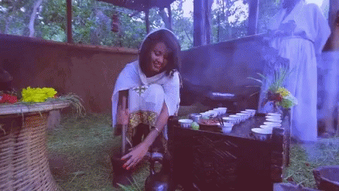 Woman Sitting On Ground At Table With Cups GIF