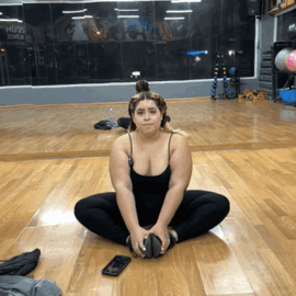 Woman Sitting on Gym Floor with Phone
