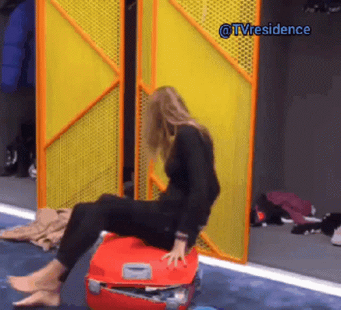 Woman Sitting on Red Suitcase by Yellow Door @tvresidence