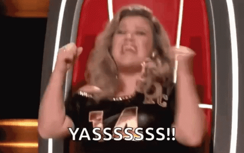 Woman Sitting with Arms Up Saying Yasss