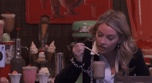 Woman Sitting With Spoon In Mouth GIF
