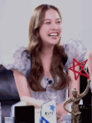 Woman Sitting With Statue And Trophy GIF