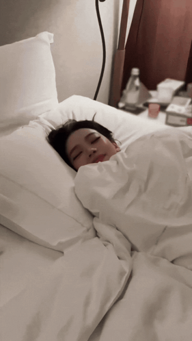 Woman Sleeping in Bed with White Sheets