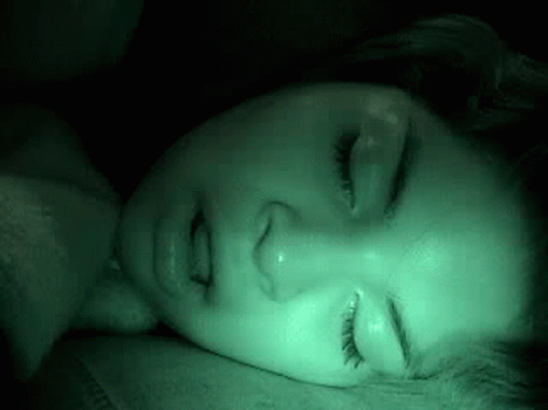Woman Sleeping in Dark Room with Green Light