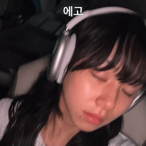 Woman Sleeping with Headphones in Dark Room