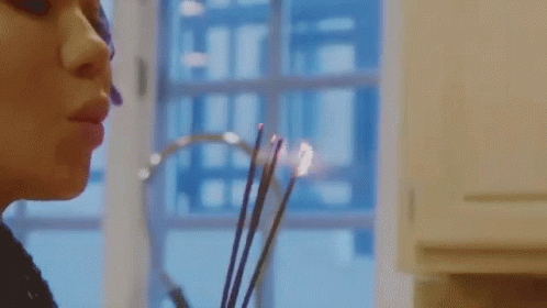 Woman Smelling Candle By Window GIF