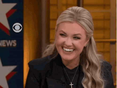 Woman Smiling In Front Of CBS News Sign GIF