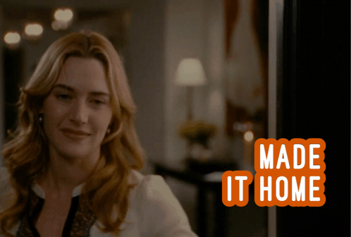 Woman Smiling in Front of Made It Home Sign