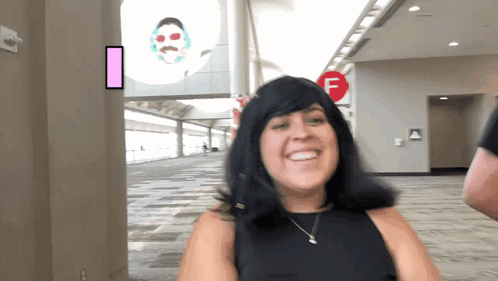 Woman Smiling In Front Of Red F Sign GIF