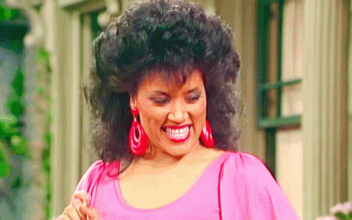 Woman Smiling in Pink Top and Red Earrings