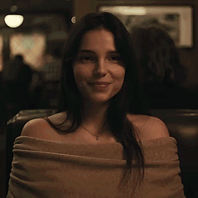 Woman Smiling in Restaurant with Sweater and Necklace
