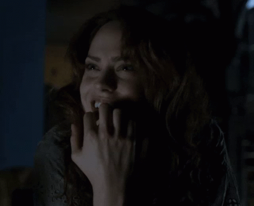 Woman Smiling in the Dark With Hand on Face